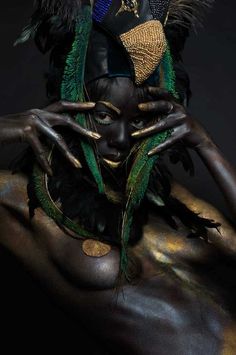 a woman with black skin and green feathers on her head