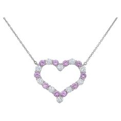 Large Tiffany & Co. Pink Sapphire and Diamond Heart Pendant Necklace featuring fine cut round brilliant diamonds and round cut pink sapphires set in platinum. The diamonds weigh approximately 1 carat in total and are of fine quality with colors of E-F and clarities of VS1+. The pink sapphires are exceptional vivid pink in color and weigh approximately 1.30 carats in total. The pendant measures 1 x .88 inches while the necklace measures 16 inches in length overall. The pendant is stamped Tiffany Formal Pink Diamond Necklace, Pink Diamond Necklace Gift, Pink Diamond Necklace As Gift, Pink Diamond Necklace For Gift, Pink Heart-shaped Diamond Necklace, Pink Diamond Heart Cut Necklace, Luxury Pink Heart Cut Necklace, Formal Pink Heart Cut Necklace, Diamond Heart Pendant Necklace