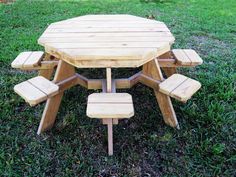 a wooden picnic table with benches in the grass