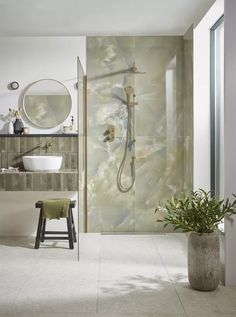 a bathroom with a sink, mirror and shower head in the corner next to a stool