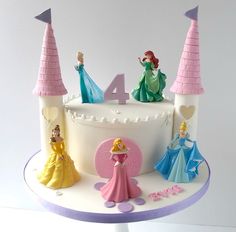 a birthday cake with princess figurines on top and the number four in front