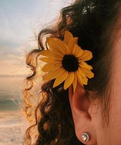 a close up of a person's ear with a sunflower in the middle