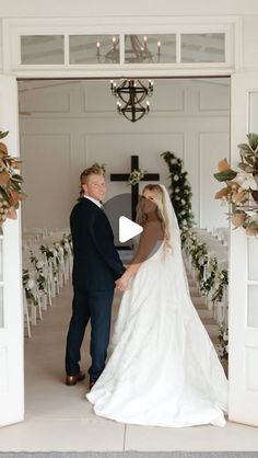 a bride and groom standing in front of an open door at their wedding ceremony,