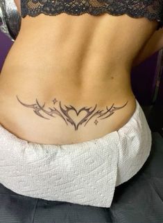 a woman's lower back tattoo with birds and hearts on her stomach, in black ink