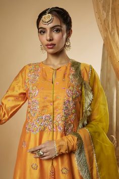 Light orange kurta featuring floral motifs hand embroidered neckline with pitta work, multicolored glass beads and resham with glass beads latkan. Paired with matching palazzo and contrast olive green dupatta with gold shimmer fringes all over. - Aza Fashions Orange Dola Silk Sets With Resham Embroidery, Fitted Embroidered Orange Anarkali Set, Festive Orange Silk Choli, Orange Sets With Resham Embroidery In Traditional Drape, Orange Resham Embroidery Sets For Navratri, Festive Orange Sets With Resham Embroidery, Orange Raw Silk Sets With Zari Work, Orange Designer Wear Sets With Traditional Drape, Orange Embroidered Art Silk Sharara