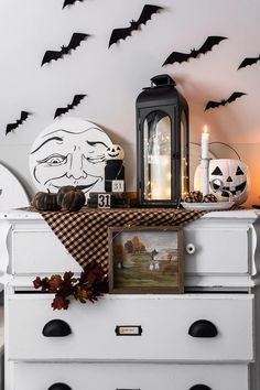 a white dresser topped with lots of halloween decorations