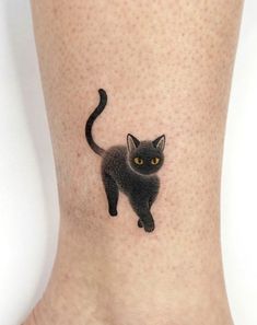 a small black cat tattoo on the ankle