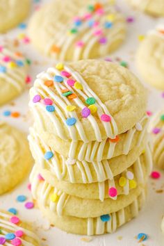 white frosted cookies stacked on top of each other with colorful sprinkles