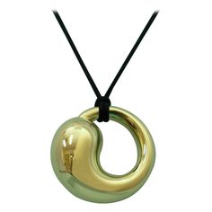 TIFFANY & Co. Elsa Peretti 18K Gold 35mm Eternal Circle Pendant Necklace Extra LARGE Metal: 18K yellow gold Gold weight: 17.10 grams Pendant: 35mm(1.38") wide, Extra-large size Silk Cord: Tiffany 20" black silk cord Hallmark: TIFFANY&Co. ©Elsa Peretti 750 SPAIN Condition: New, comes with Tiffany pouch, box, bag and ribbon bow Limited edition, no longer available for sale in Tiffany stores Authenticity Guaranteed Elsa Peretti, Circle Pendant Necklace, Silk Cord, Tiffany And Co, Circle Pendant, Style Jewelry, Gold Gold, Ribbon Bows, Tiffany & Co.