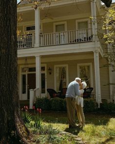 an older couple standing in front of a house