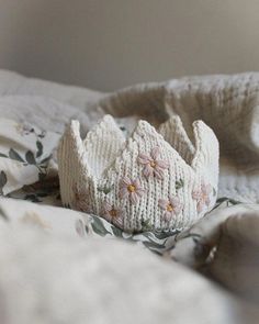 a knitted crown laying on top of a bed