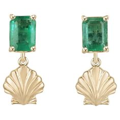 These stunning emerald stud earrings feature natural emeralds with lush green color and beautiful characteristics. The emeralds are expertly cut in an emerald cut style and securely set in a four-prong basket setting, showcasing their brilliance. Adding a touch of whimsy and elegance, a gorgeous gold sea shell dangles from each stud. Crafted in 14k gold, these earrings combine the natural beauty of emeralds with the charm of sea-inspired design, creating a unique and captivating accessory. Setti Luxury Emerald Earrings For May Birthstone, Fine Jewelry Emerald Cut May Birthstone Earrings, Classic Emerald Dangle Jewelry, Fine Jewelry Emerald Cut Earrings For May Birthstone, May Birthstone Emerald Cut Fine Jewelry Earrings, Fine Emerald Earrings For May Birthstone, Yellow Gold Emerald Drop Earrings, Yellow Gold Emerald Dangle Jewelry, Emerald Cut Emerald Earrings Fine Jewelry