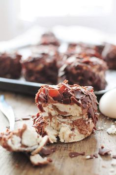 a chocolate dessert with ice cream and cherries is on a cutting board next to a spoon