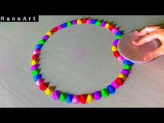 a person is using a mouse to make a colorful bracelet