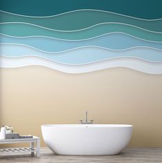 a bath tub sitting in front of a wall with waves painted on it's side