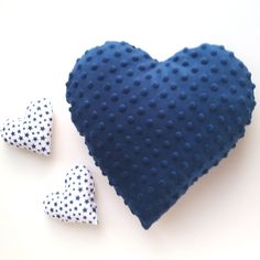 two blue and white heart shaped cushions next to each other on a white surface with polka dots