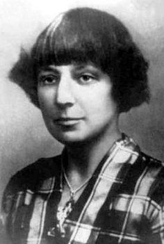 an old black and white photo of a woman with short hair wearing a plaid shirt