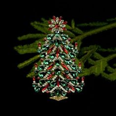 a christmas tree ornament is shown on a black background with green and red ornaments