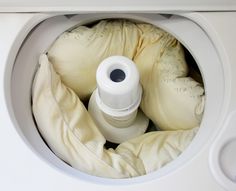 an open washing machine with some bags in it