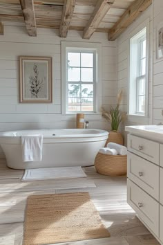 a bathroom with white walls and wood floors, an oval bathtub in the center