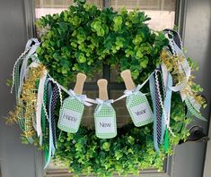 a wreath decorated with green and white ribbon hanging from the front door to celebrate new year's eve