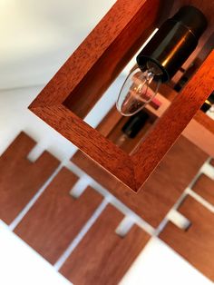 a wine glass hanging from the side of a wooden shelf