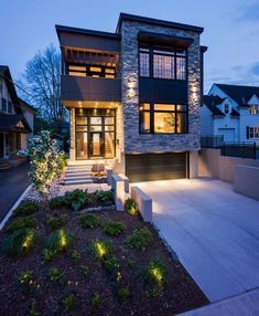 a modern house with lights on the front and side