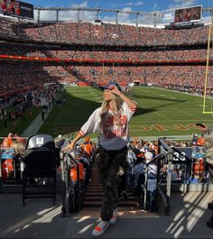 a woman standing on the sidelines at a football game