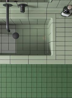 an overhead view of a green tiled bathroom with two sinks and soap dispenser