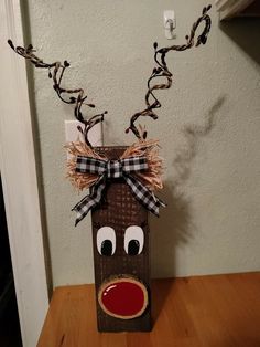 a cardboard bag with a reindeer face on it and a ribbon tied around the nose