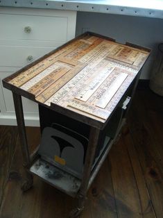 a kitchen island made out of wood and metal with words written on the top, sitting in front of a window