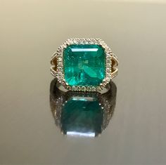 DeKara Designs Collection Metal- 18K Yellow Gold, .583. Stones- 1 Emerald Cut Green Colombian Emerald 7.12 Carats, 10.9 x 11.1 MM. 92 Round Diamonds G Color VS2 Clarity, 1.00 Carats. Art Deco Inspired Beautifully Cut and Colored Colombian Green Emerald Halo Diamond Engagement Ring Made in 18K Yellow Gold. . The pictures do not capture the true beauty, brilliance, and color of this Emerald ring. The Emerald is as square as possible for the best possible proportions. The emerald is surrounded by 3 Gia Certified Yellow Gold Emerald Ring For Formal Occasions, Luxury Gold Emerald Ring For Wedding, Dazzling Emerald Ring With Accent Stones For Wedding, Formal Gia Certified Yellow Gold Emerald Ring, Luxury Yellow Gold Cushion Cut Emerald Ring, Luxury Cushion Cut Emerald Ring In Yellow Gold, Gia Certified Gold Halo Ring Fine Jewelry, Formal Gold Emerald Ring Gia Certified, Luxury Emerald Ring With Accent Stones For Wedding