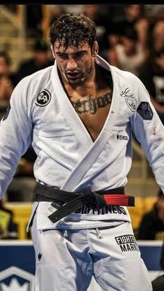 a man standing in front of a crowd wearing a black belt