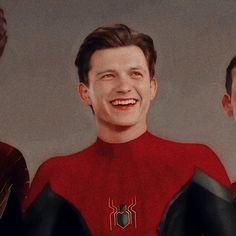 two men in spider - man suits are smiling at the camera