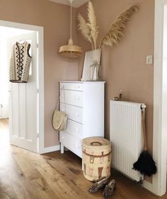 a white dresser sitting next to a radiator in a living room