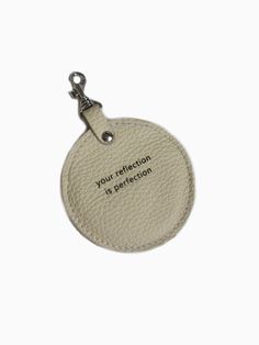 a white leather tag with the words your reflection is perfection