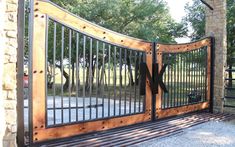 an iron and wood gate on the side of a house