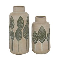 two vases with leaves on them sitting next to each other