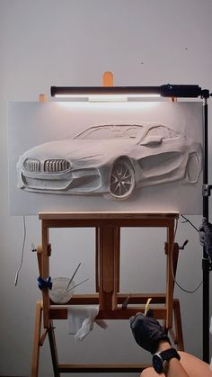 a person is painting a car on a canvas