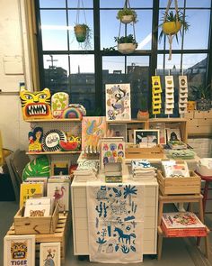 an assortment of children's art and crafts displayed in front of a large window