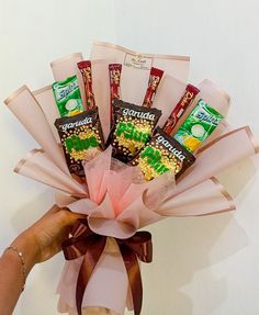 a person holding a bouquet of chocolates and candy bars