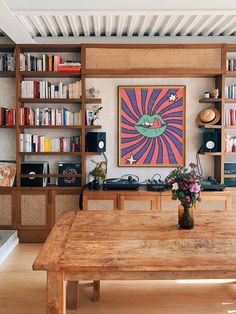 a wooden table sitting in front of a book shelf filled with books