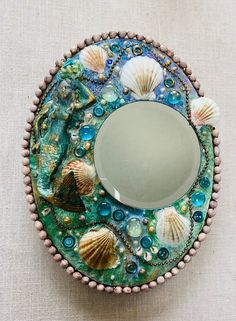 a mirror with seashells and pearls on it