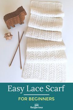 an easy lace scarf for beginners is shown with knitting needles and a wooden toy