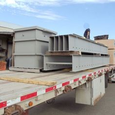 the flatbed trailer is loaded with large metal boxes