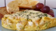 an omelet on a plate with bread and grapes