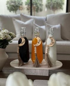 three bottles of liquid sitting on top of a table