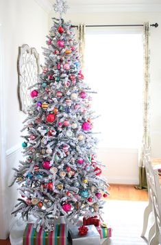 a white christmas tree with colorful ornaments