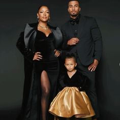 the couple and their daughter are posing for a family photo in front of a black background