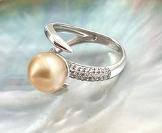 Elegant 10mm Golden South Sea Cultured Pearl Ring with White Zircon. Ring is set in Rhodium Plated 925 Sterling Silver with White Zircon. The Pearls are High Luster 10mm Natural Golden South Sea. Available in US Ring Size 9.     Only 1 in stock!      Pearl Type: Golden South Sea Cultured (No Treatment)  Pearl Size: 10mm  Pearl Color: Natural Golden  Pearl Origin: Philippines      Metal Type: Rhodium Plated 925 Sterling Silver      Stone Type: White Zircon  Stone Shape: Round   Treatment: Heated Baby Oyster, Cultured Pearl Ring, Golden Pearl, Pearl Farm, Country Rings, Buy Pearls, Golden South Sea Pearls, Pearl Shop, Zircon Ring